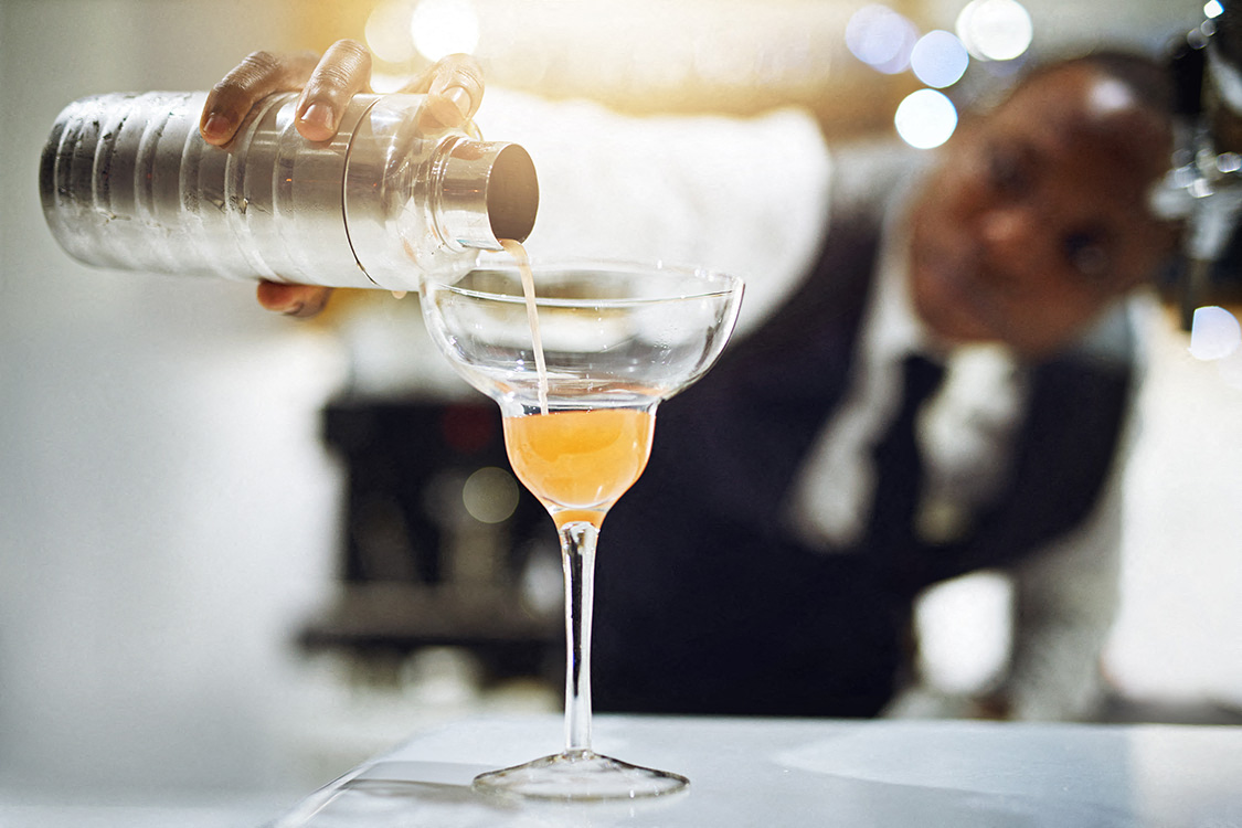 Bartender pouring a cocktail representing nearby bars and dining by Lux Apartments Bellevue